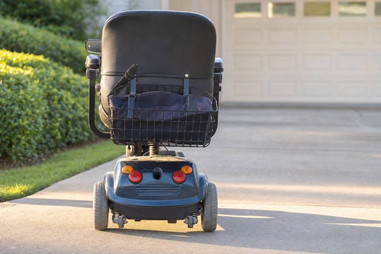 A mobility scooter parked alone on a home driveway.