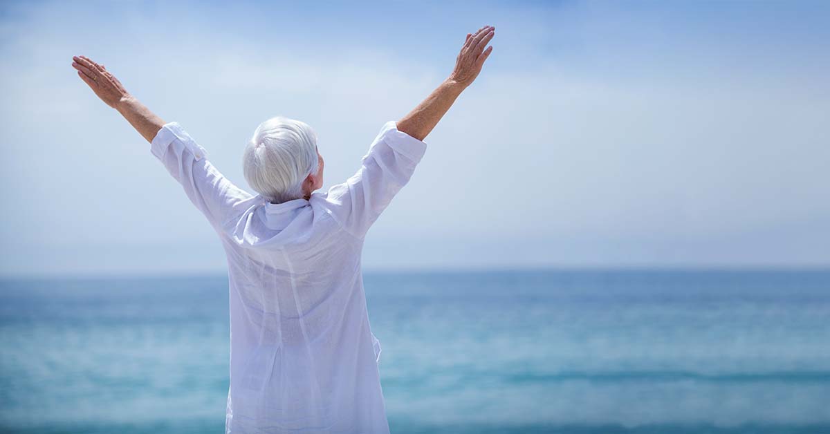 Senior woman stretching on the beach