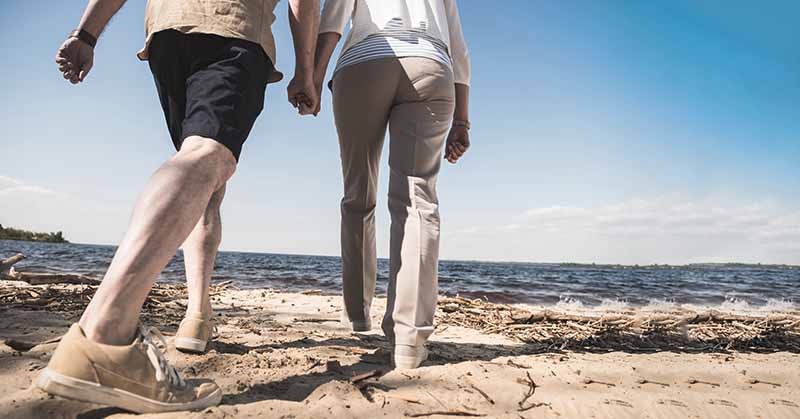 Senior couple walking on the sandy beach