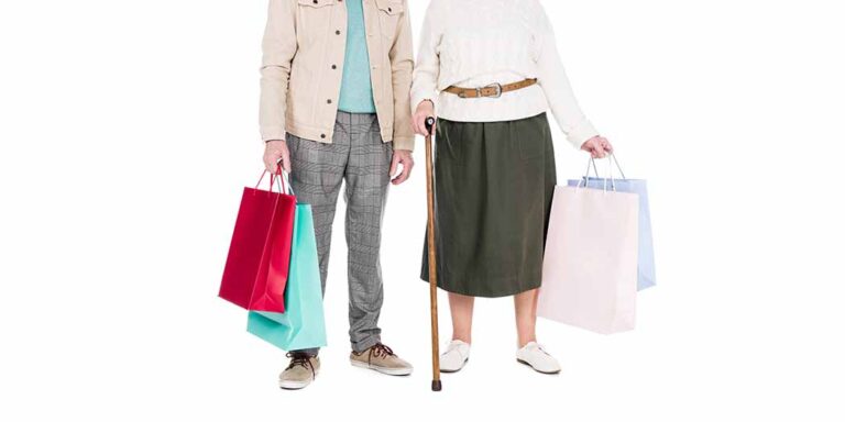 couple standing with walking cane and shopping bags